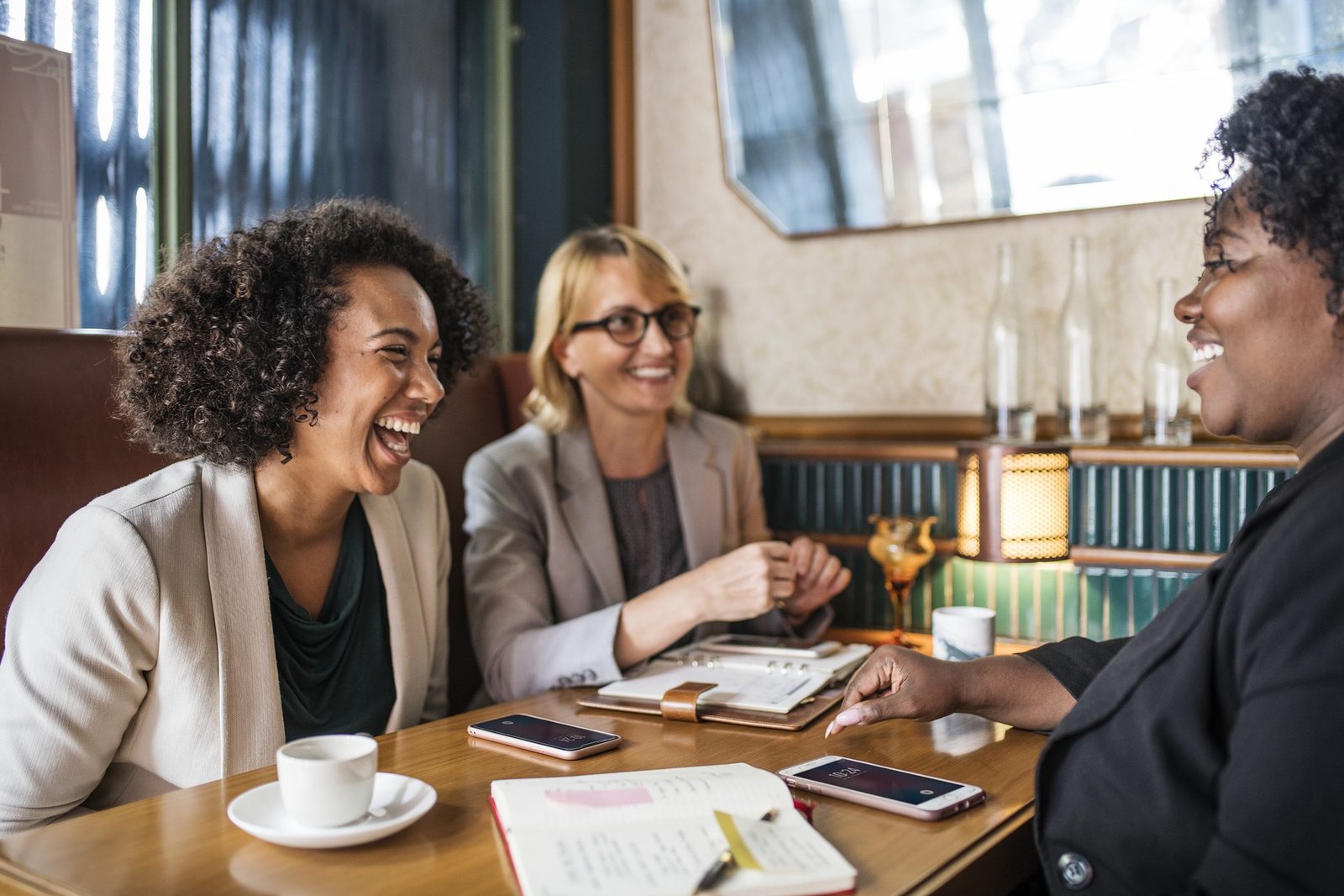Three women laughing together at a table