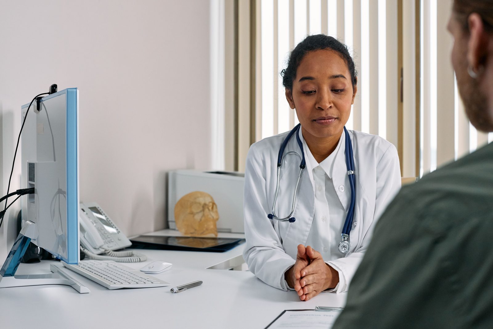 A doctor listening to a patient in an exam room