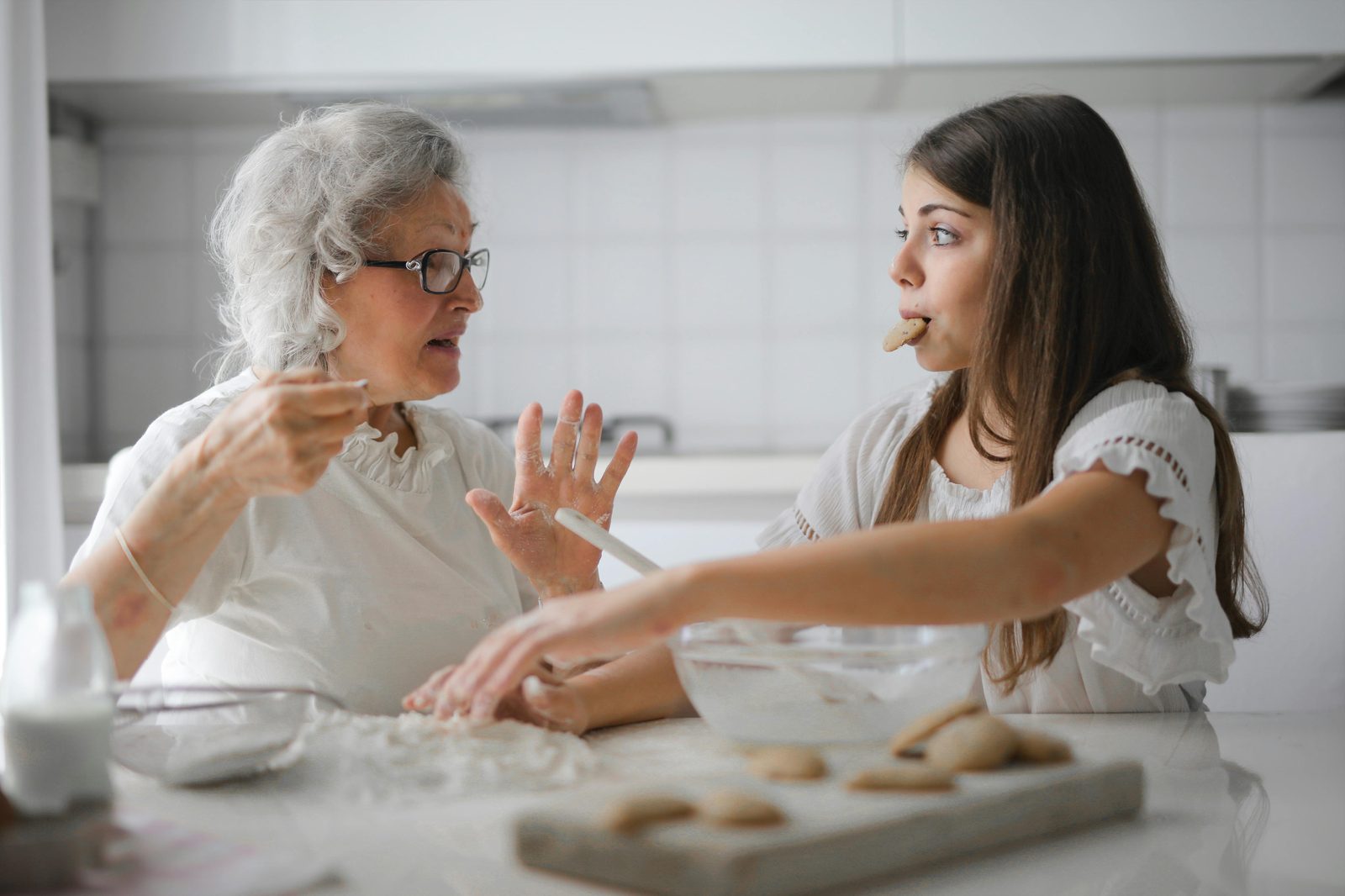 A grandmother and granddaughter talking while baking